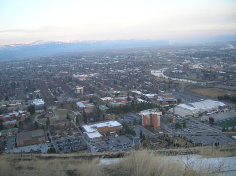 1996 Ford Bronco - An aerial view of a city with mountains in the background, featuring buildings, a river, and a sports stadium.