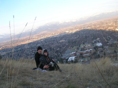 1996 Ford Bronco - A young couple sits on a grassy hillside overlooking a city and mountains in the distance.