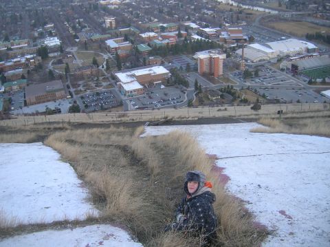 1996 Ford Bronco - A person sits on a snowy hillside overlooking a large university campus and a football stadium.