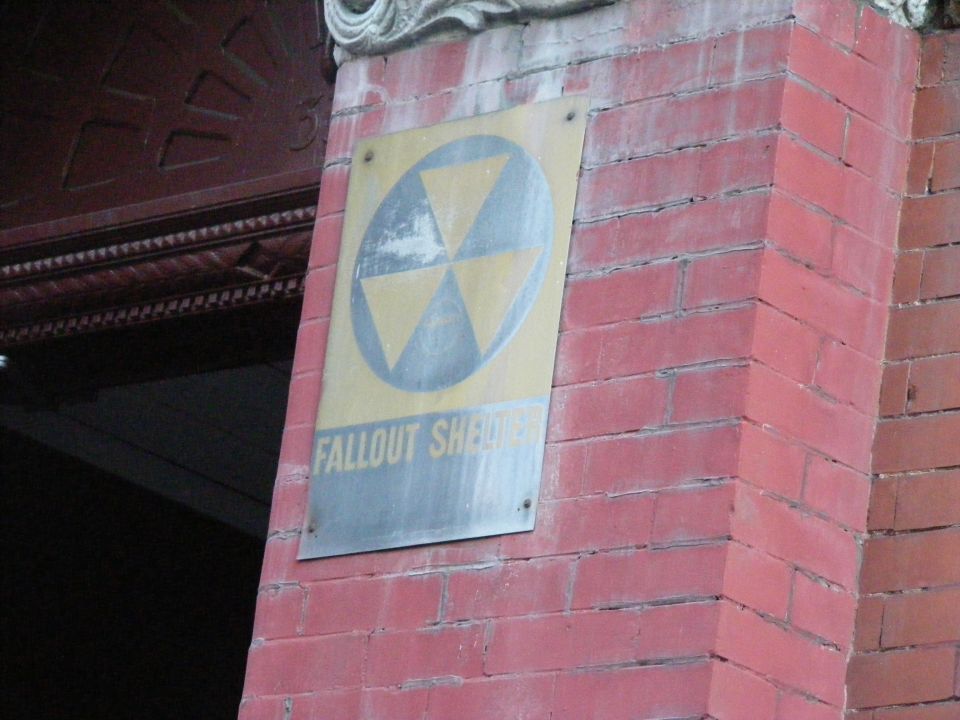 Fallout shelter sign on a red brick wall