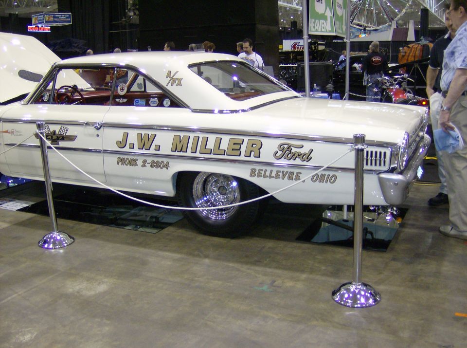 White 1960s Ford sedan with gold lettering on the side.