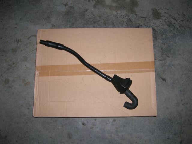 Black curved engine vacuum or breather hose on cardboard