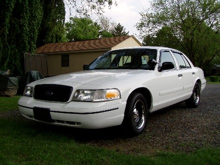 1999 Ford Crown Victoria - White Ford Crown Victoria, likely a 1998 model, seen from the front-right in a residential setting.