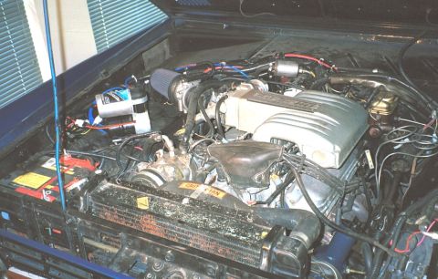 1986 Ford Bronco - Close-up view of a vehicle's engine bay, showing the engine, air filter, and various components.
