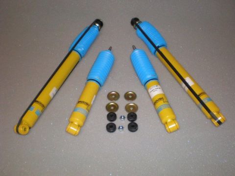 2007 Ford Mustang - Set of four yellow and blue shock absorbers, likely for a performance vehicle, with accompanying mounting hardware.
