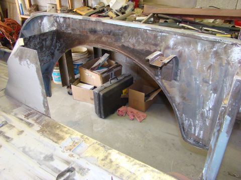 1948 Jeep Wrangler - This unfinished metal body panel and rear fender are undergoing repair or modification, with visible welding and primer application.