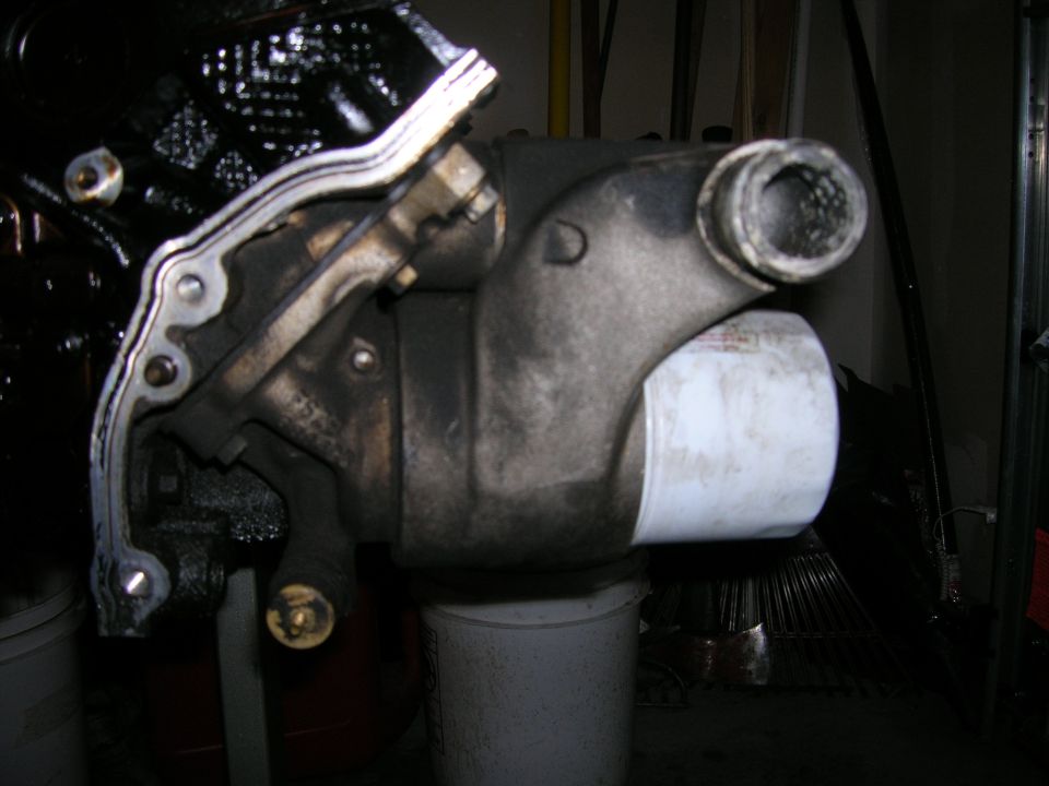 Used cast metal engine thermostat housing with hose neck