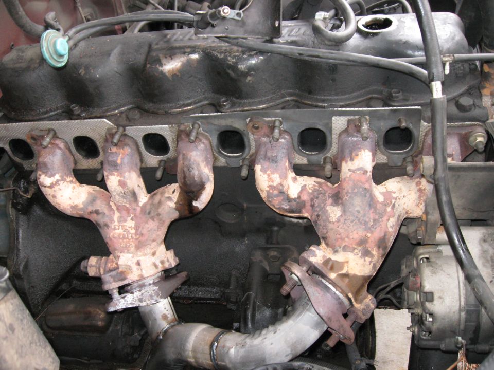 A picture from a later date, but this shows how I replaced all of the original manifold bolts with high grade hardened studs.  This made the job of balancing THREE manifold pieces at once much easier since at the time there was no exhaust pipe to help hold things in place.

I highly recommend switching to manifold studs.