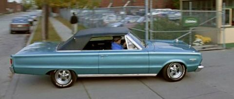 1990 Ford Bronco - A blue 1967 convertible is seen driving down a street with another car in the background.