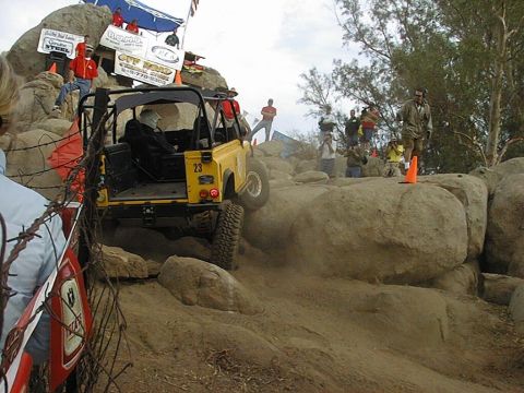 1997 Ford Ranger - A yellow off-road vehicle tackles a challenging rocky course during an event.