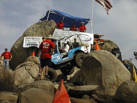 1997 Ford Ranger - An off-road competition features a blue jeep navigating a challenging rocky course.