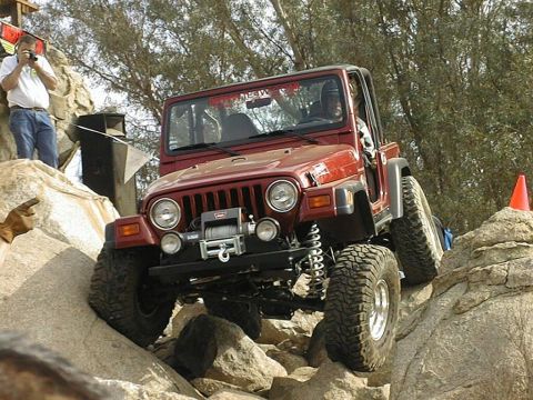 1997 Ford Ranger - A red Jeep Wrangler navigates a rocky obstacle course with a photographer observing from a higher vantage point.
