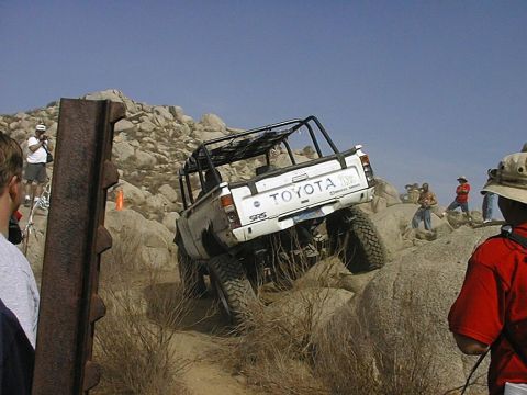 1997 Ford Ranger - Off-road Toyota pickup navigates a rocky trail with spectators watching.