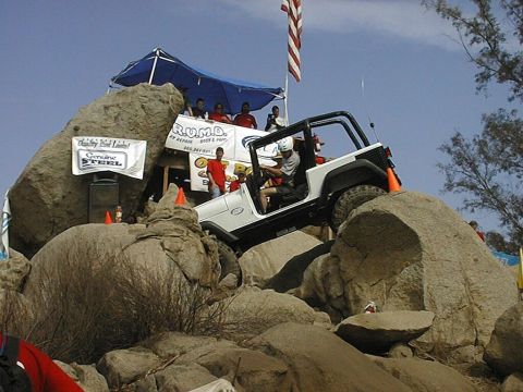 1997 Ford Ranger - A white Jeep Wrangler navigates a rocky obstacle course during an event.