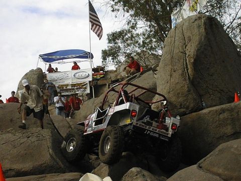 1997 Ford Ranger - An off-road vehicle navigates a rocky course with spectators watching.