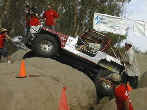 1997 Ford Ranger - A custom off-road buggy navigates a rocky course with spectators and media present.