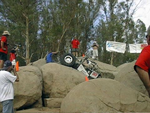 1997 Ford Ranger - A custom-built off-road vehicle attempts to conquer a challenging rock climb during an event.