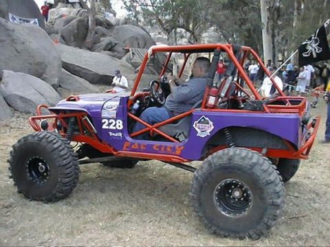 1997 Ford Ranger - This modified buggy is participating in an off-road event with spectators in the background.
