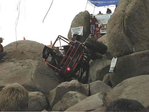 1997 Ford Ranger - An off-road buggy is stuck on a rocky incline during an event, with spectators observing from above.