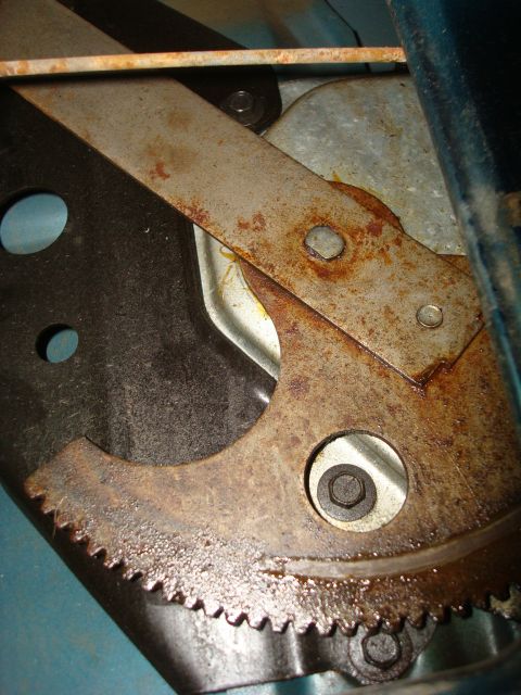 1995 Ford Bronco - Close-up of a rusty window regulator mechanism, likely from a vehicle door.