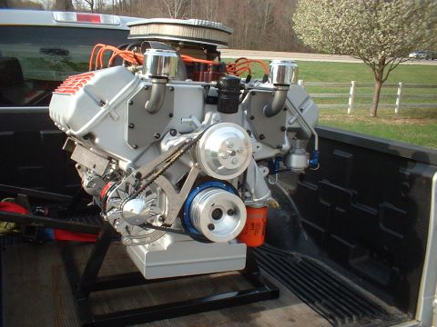 1970 Ford Mustang - Custom engine assembly with prominent pulleys and air filter, displayed in the bed of a pickup truck.