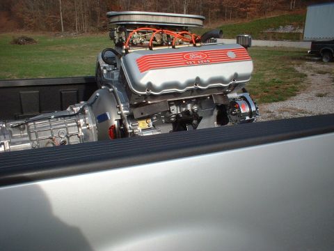 1970 Ford Mustang - A Ford 427 engine and transmission are loaded into the bed of a pickup truck.