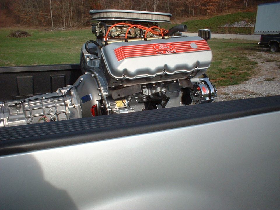 Ford 427 engine and transmission in truck bed. Supermotors.net logo visible