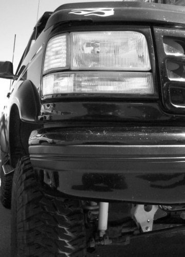 1995 Ford Bronco - Close-up of the front end of a black Ford Bronco, showing the headlight and grille details.