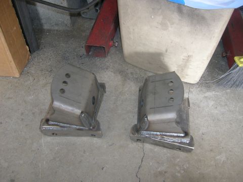 1996 Ford Bronco - Two custom-fabricated steel brackets are shown on a garage floor.