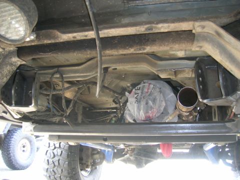 1996 Ford Bronco - The underside of a 1996 Ford Bronco reveals its suspension components and exhaust system, with another vehicle visible in the background.