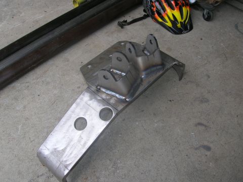1996 Ford Bronco - A custom-fabricated metal bracket with visible welds and mounting holes is shown on a concrete surface.