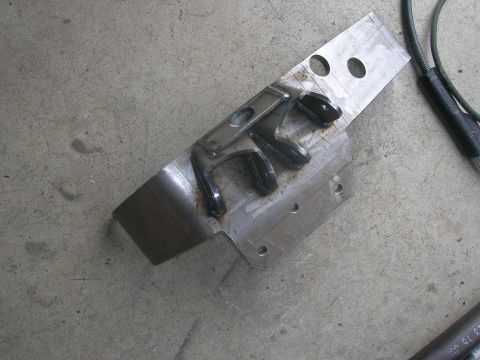 1996 Ford Bronco - A close-up view of a vehicle's rear suspension component resting on a concrete surface.