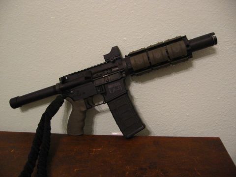 1996 Ford Bronco - A shotgun is pictured, leaning against a wall and resting on a wooden surface.