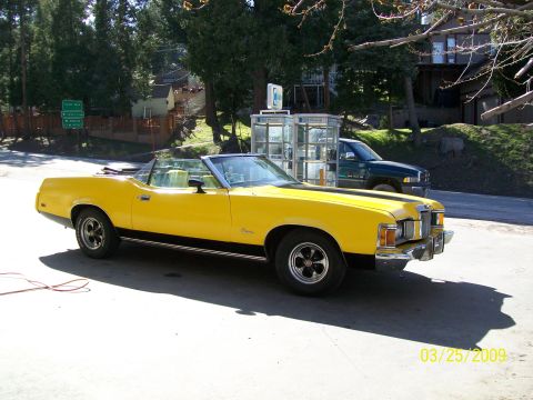 1973 Mercury Cougar - Yellow 1973 Mercury Cougar convertible parked outdoors with a dark green truck in the background.
