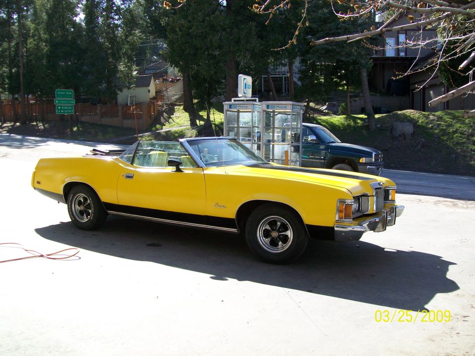 Yellow Mercury Cougar convertible parked outdoors, 3/4 front view