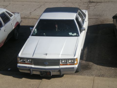 1988 Ford Crown Victoria LTD - A white sedan with a black vinyl roof is parked outdoors, viewed from above.