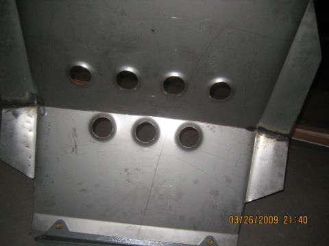 1909 Ford Bronco - This metal part, likely a skid plate, features several circular holes and visible weld marks.