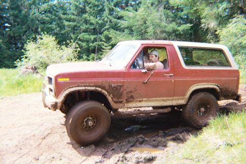 1985 Ford Bronco - This muddy Ford Bronco navigates a challenging off-road course.
