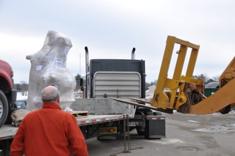 1996 Ford Bronco - Forklift loading a large, wrapped item onto a flatbed truck next to a semi-truck.