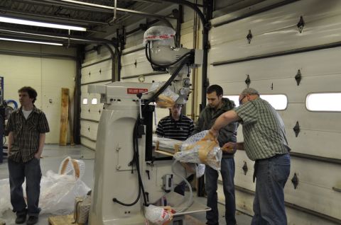 1996 Ford Bronco - Men unboxing a large piece of industrial equipment in a workshop setting.