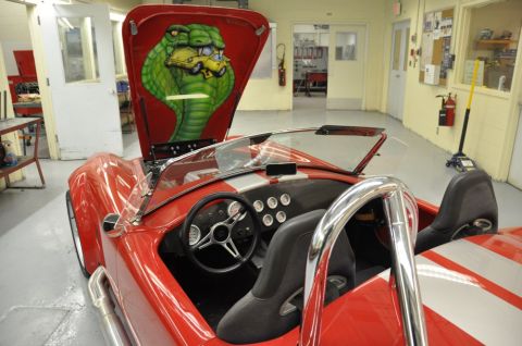 1996 Ford Bronco - Interior view of a red convertible a striking cobra mural painted on the underside of the hood.