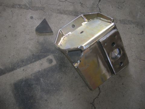 1996 Ford Bronco - A fabricated metal bracket sits on a concrete surface next to a small triangular metal piece.