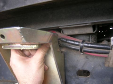 1996 Ford Bronco - Close-up view of a metal bracket and battery cables attached to the underside of a vehicle.