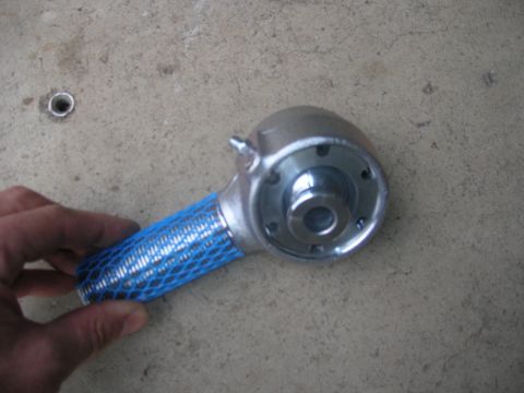 1996 Ford Bronco - A metal suspension component, possibly from a vehicle's rear suspension, is held for inspection.