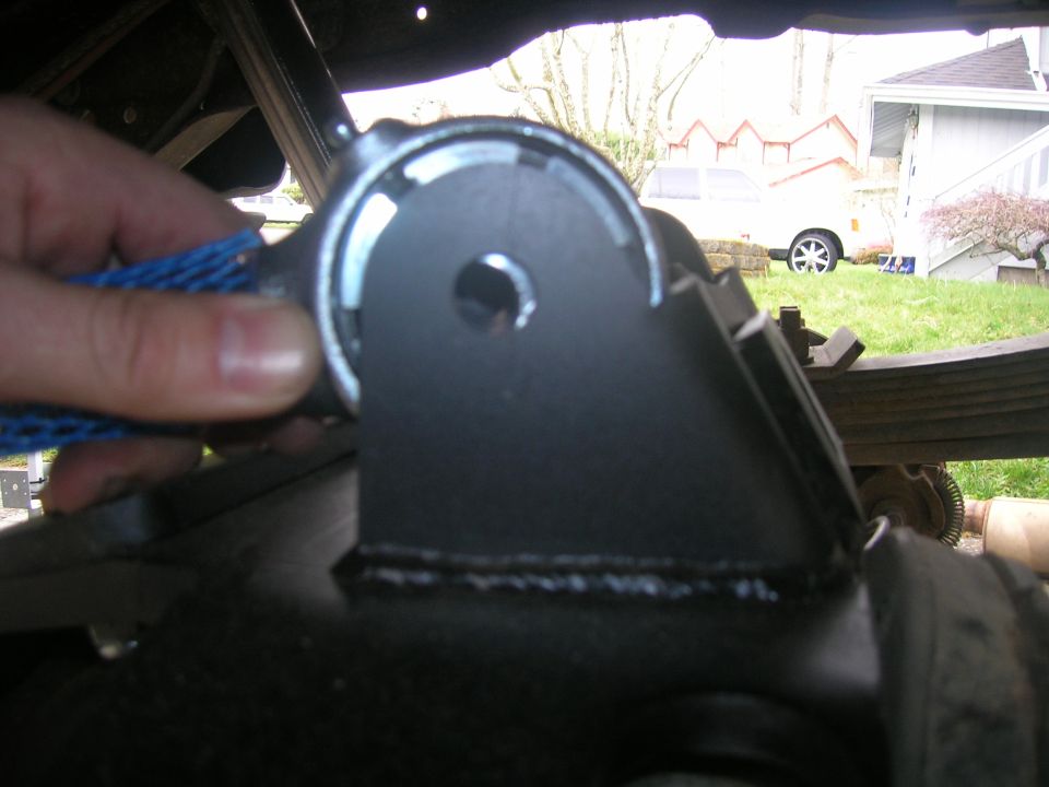 Black metal suspension bracket with a hand holding a blue mesh sleeve
