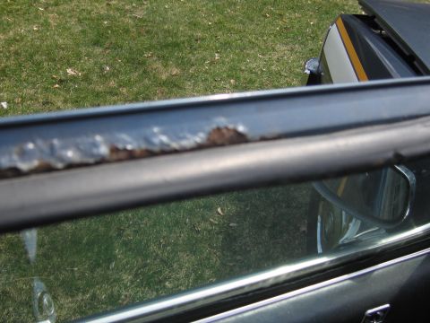 1991 Ford LTD Crown Victoria - Rusted window trim on a car door, showing signs of wear and tear.