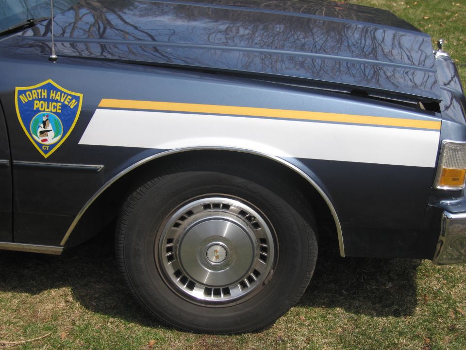 1991 Ford Crown Victoria LTD police car side view showing fender, wheel, and North Haven Police badge