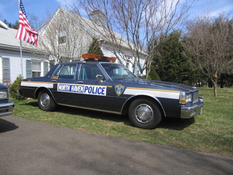 1991 Ford LTD Crown Victoria - A North Haven Police car is parked on a grassy area in front of a house.
