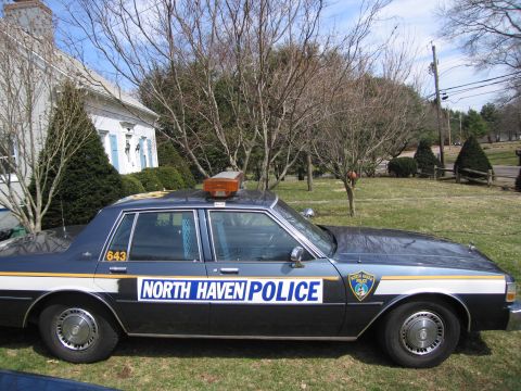 1991 Ford LTD Crown Victoria - A North Haven Police car is parked on a grassy lawn in front of a white house.