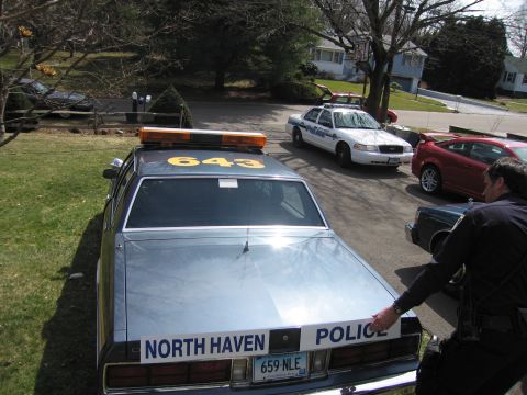 1991 Ford LTD Crown Victoria - Police car with light bar and 'NORTH HAVEN POLICE' text. Other vehicles are parked nearby.